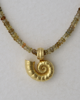 A spirula in 18K gold on string of mixed Sapphire beads